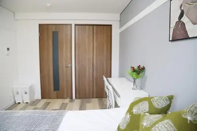a bedroom with a bed and a wooden door at Pr42\u4e0b\u843d\u5408 in Tokyo