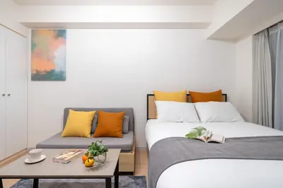 a room with two beds and a table and a couch at \u30ec\u30b8\u30c7\u30a3\u30a2\u4e2d\u843d\u5408c in Tokyo