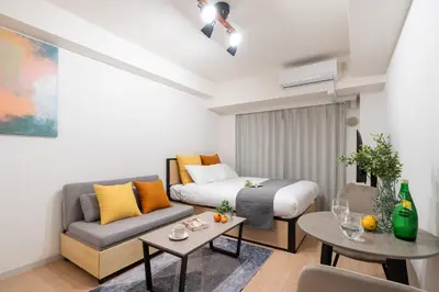 a living room with a bed and a couch at \u30ec\u30b8\u30c7\u30a3\u30a2\u4e2d\u843d\u5408c in Tokyo