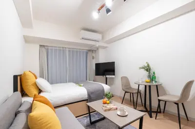 a room with a bed and a couch and a table at \u30ec\u30b8\u30c7\u30a3\u30a2\u4e2d\u843d\u5408c in Tokyo