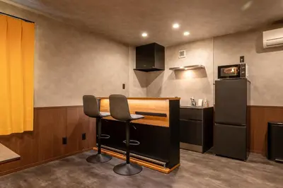 a kitchen with a bar with a chair and a refrigerator at SEEK Tokyo in Wada