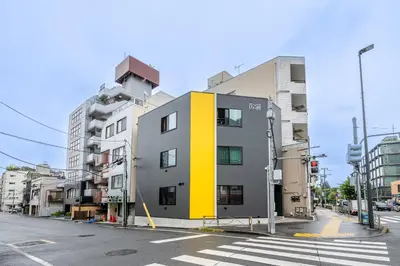 a yellow and gray building on a city street at SEEK Tokyo in Wada