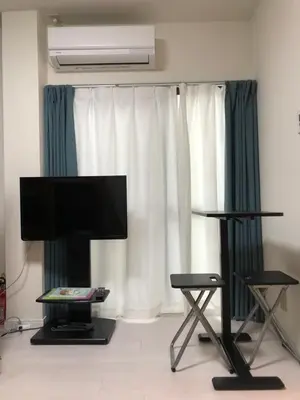 a living room with a flat screen tv and two chairs at \u685c\u5c4bSakuraya201 in Tokyo