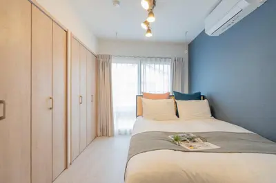 a bedroom with a large bed and a window at \u30b3\u30f3\u30dd\u30b8\u30c3\u30c8\u5927\u68ee in Tokyo