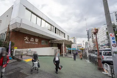 a group of people walking down a city street at \u30b3\u30f3\u30dd\u30b8\u30c3\u30c8\u5927\u68ee in Tokyo