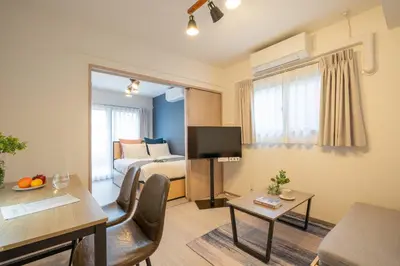 a hotel room with a bedroom with a bed and a television at \u30b3\u30f3\u30dd\u30b8\u30c3\u30c8\u5927\u68ee in Tokyo