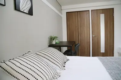 a bedroom with a white bed with a black and white pillow at Pr43 \u4e0b\u843d\u5408 in Tokyo