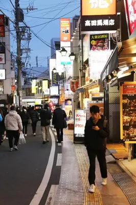 a man walking down a street in a city at Pr44\u4e0b\u843d\u5408 in Tokyo