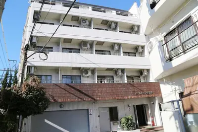 an apartment building with a garage in front of it at Pr44\u4e0b\u843d\u5408 in Tokyo