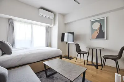 a bedroom with a bed and a table and chairs at \u30b3\u30b9\u30e2\u30ea\u30fc\u30c9\u5e61\u30f6\u8c37 in Tokyo