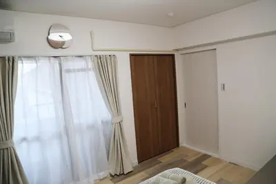a bedroom with a window and a door with curtains at Pr46 \u4e0b\u843d\u5408 in Tokyo