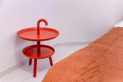 a red table and stool next to a bed at Hotel Comfortia in Tokyo