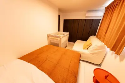 a small room with a bed and a chair at Hotel Comfortia in Tokyo
