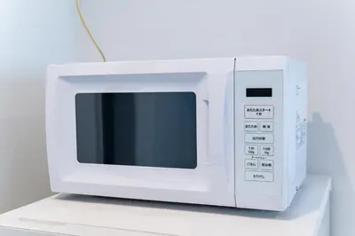 a white microwave oven sitting on top of a counter at Hotel Comfortia in Tokyo