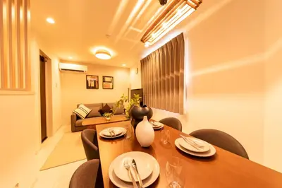a dining room with a table and chairs and a couch at Hotel Comfortia in Tokyo