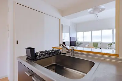 a kitchen with a stainless steel sink and a mirror at Tokyo Flash Hideout in Tokyo