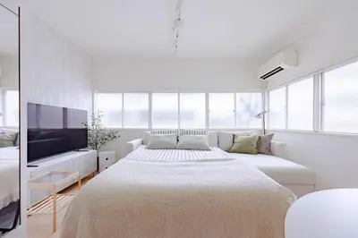 a white bedroom with a large bed and a tv at Tokyo Flash Hideout in Tokyo