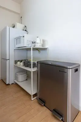 a kitchen with a refrigerator and a shelf with appliances at Tokyo Flash Hideout in Tokyo