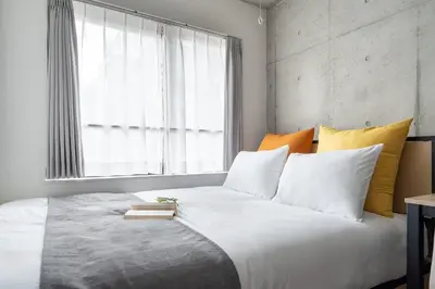 a bedroom with a large white bed with a window at MAT ARAIYAKUSHI East in Tokyo