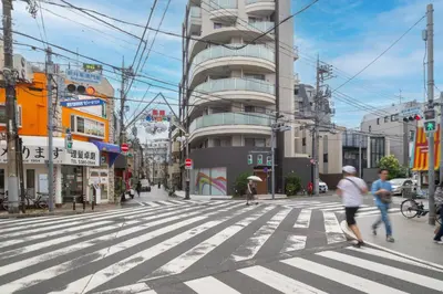 a city street with people crossing a crosswalk at MAT ARAIYAKUSHI East in Tokyo