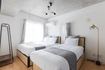 two beds in a room with white walls at MAT ARAIYAKUSHI East in Tokyo