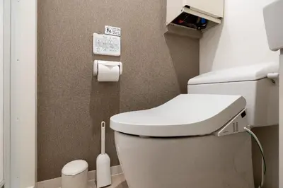 a bathroom with a toilet with a toilet brush at MAT ARAIYAKUSHI East in Tokyo