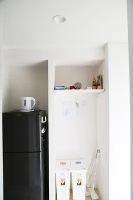a kitchen with a black refrigerator and some boxes at Pr52\u4e0b\u843d\u5408 in Tokyo