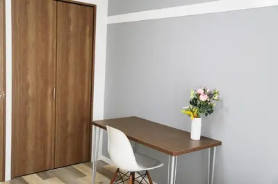 a table and two chairs and a vase with flowers at Pr52\u4e0b\u843d\u5408 in Tokyo