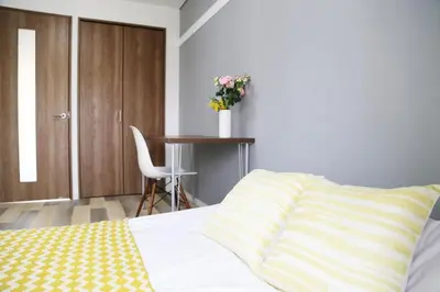 a bedroom with a bed and a table with a vase of flowers at Pr52\u4e0b\u843d\u5408 in Tokyo