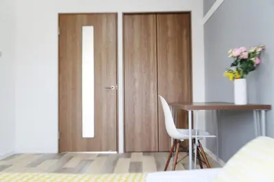 a bedroom with a desk and a door with a table at Pr52\u4e0b\u843d\u5408 in Tokyo