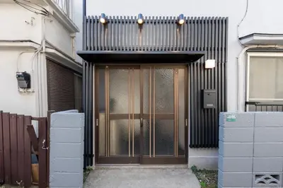 a entrance to a building with a wooden door at \u4e0a\u6c60\u888b\u6238\u5efa\u3066 in Tokyo