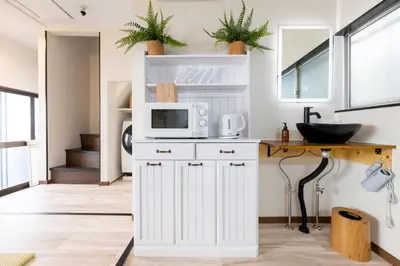 a kitchen with a sink and a microwave at \u4e0a\u6c60\u888b\u6238\u5efa\u3066 in Tokyo