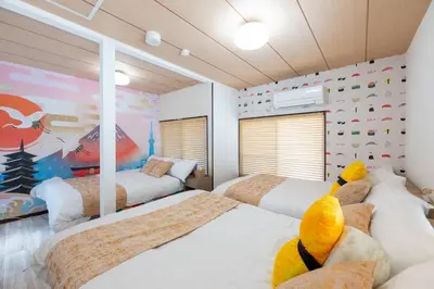 a bedroom with two beds with a stuffed animal on the pillows at \u4e0a\u6c60\u888b\u6238\u5efa\u3066 in Tokyo