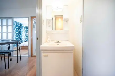 a white bathroom with a sink and a table at BAi\u304a\u82b1\u8336\u5c4b1\u4e01\u76ee\u30d1\u30fc\u30eb\u30cf\u30a4\u30c4201 in Tokyo