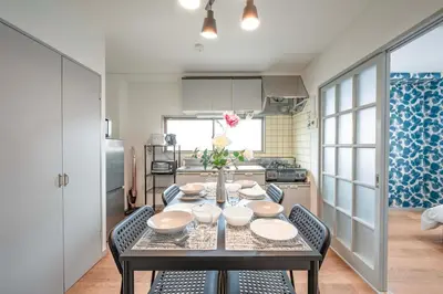 a dining room with a table and chairs and a kitchen at BAi\u304a\u82b1\u8336\u5c4b1\u4e01\u76ee\u30d1\u30fc\u30eb\u30cf\u30a4\u30c4201 in Tokyo