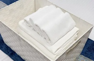 a pile of white towels in a metal tray at ginza401 in Tokyo