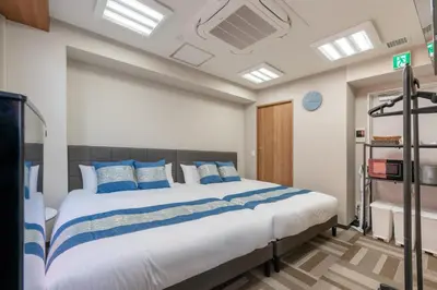 a bedroom with a large bed with blue pillows at ginza401 in Tokyo