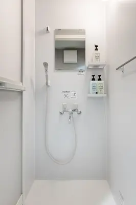 a white bathroom with a shower and a sink at ginza401 in Tokyo