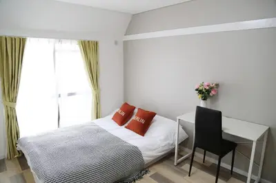 a bedroom with a bed and a desk and a window at Pr53\u4e0b\u843d\u5408 in Tokyo