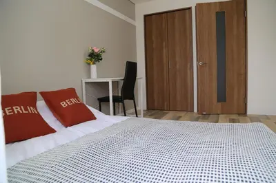 a bedroom with a bed with red pillows and a desk at Pr53\u4e0b\u843d\u5408 in Tokyo
