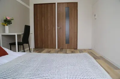 a bedroom with a bed with a wooden door and a desk at Pr53\u4e0b\u843d\u5408 in Tokyo