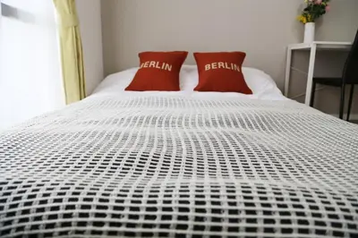 a white bed with two red pillows on it at Pr53\u4e0b\u843d\u5408 in Tokyo