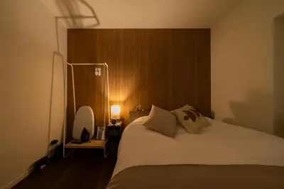 a bedroom with a white bed with a wooden headboard at \u30a2\u30f3\u30c9\u30b9\u30c6\u30a4\u5927\u5cf63\u4e01\u76ee in Tokyo
