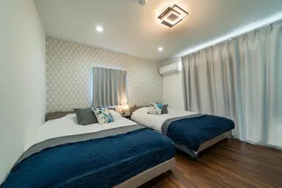 a bedroom with two beds and a window at \u30a2\u30f3\u30c9\u30b9\u30c6\u30a4\u5927\u5cf63\u4e01\u76ee in Tokyo