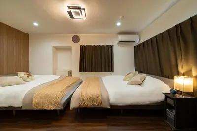 a hotel room with two beds and a window at \u30a2\u30f3\u30c9\u30b9\u30c6\u30a4\u5927\u5cf63\u4e01\u76ee in Tokyo