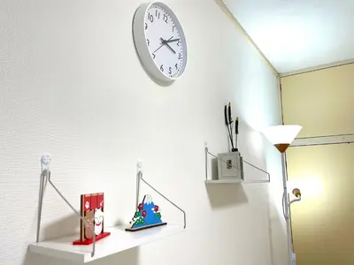 a clock hanging on a wall above a shelf at Gest house Near Disneyland in Edogawa