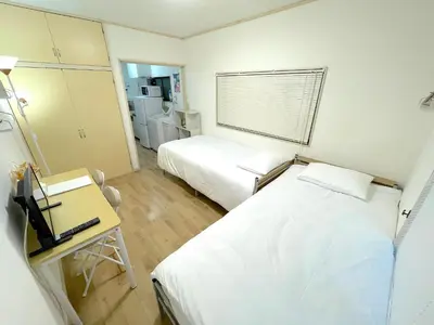 a hospital room with two beds and a desk and a mirror at Gest house Near Disneyland in Edogawa