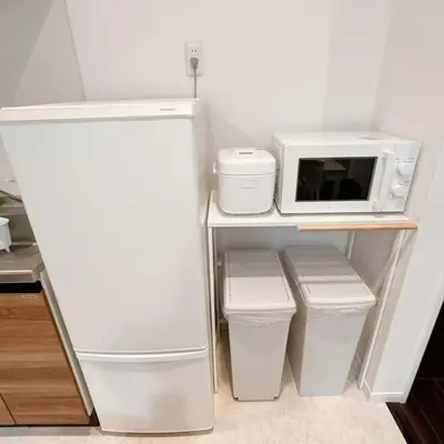 a small kitchen with a refrigerator and a microwave at \u30a2\u30f3\u30c9\u30b9\u30c6\u30a4\u91ce\u65b92\u4e01\u76ee in Tokyo