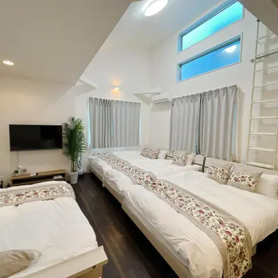 two beds in a room with a window at \u30a2\u30f3\u30c9\u30b9\u30c6\u30a4\u91ce\u65b92\u4e01\u76ee in Tokyo