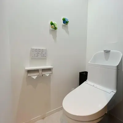 a white bathroom with a toilet and a clock on the wall at \u30a2\u30f3\u30c9\u30b9\u30c6\u30a4\u91ce\u65b92\u4e01\u76ee in Tokyo